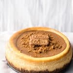 A whole lotus biscoff cheesecake on a plate with a white background
