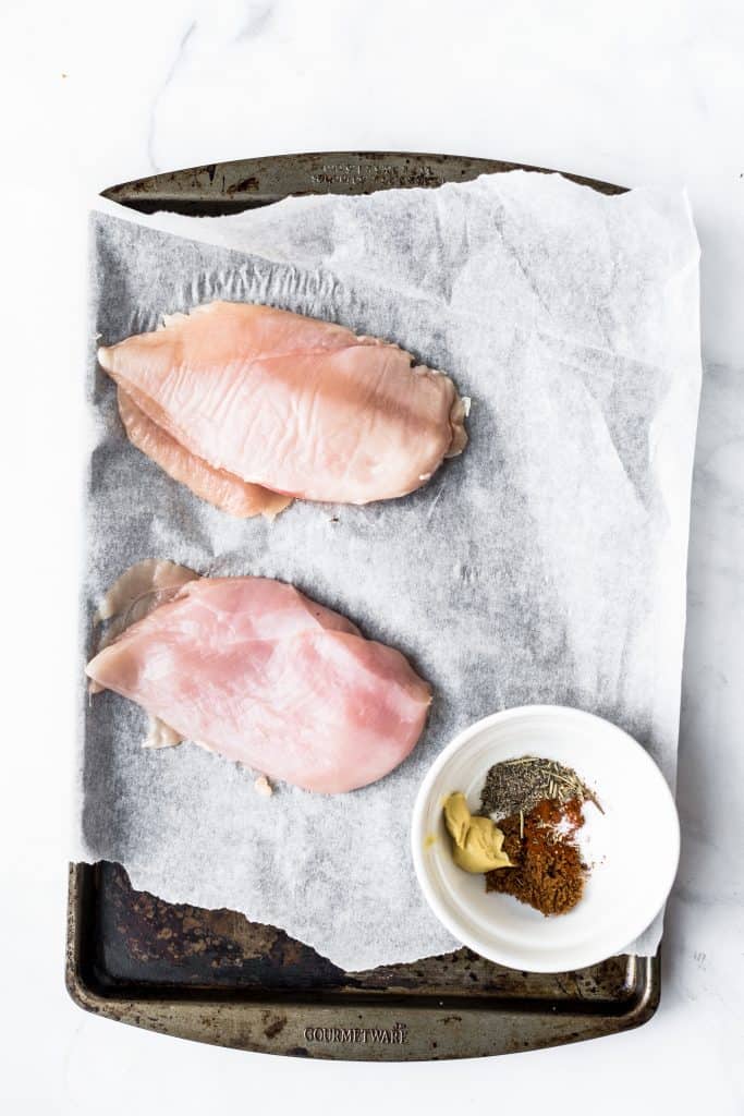 Raw chicken breasts on a baking sheet