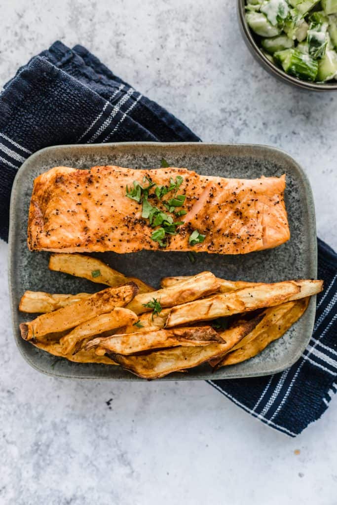 Air Fryer salmon on a plate and a kitchen towel