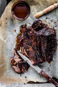Cooked brisket on parchment paper with homemade bbq sauce