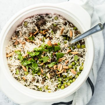 Pot of Lebanese rice hashweh with toasted nuts and parsley on top