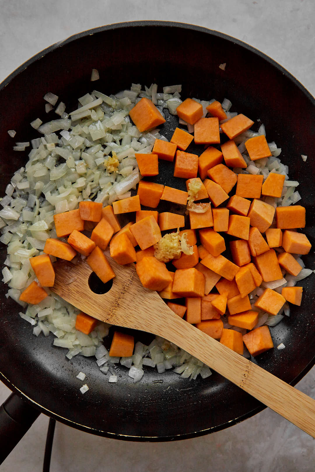Diced pumpkin cubes, crushed garlic and onion on in a large skillet.
