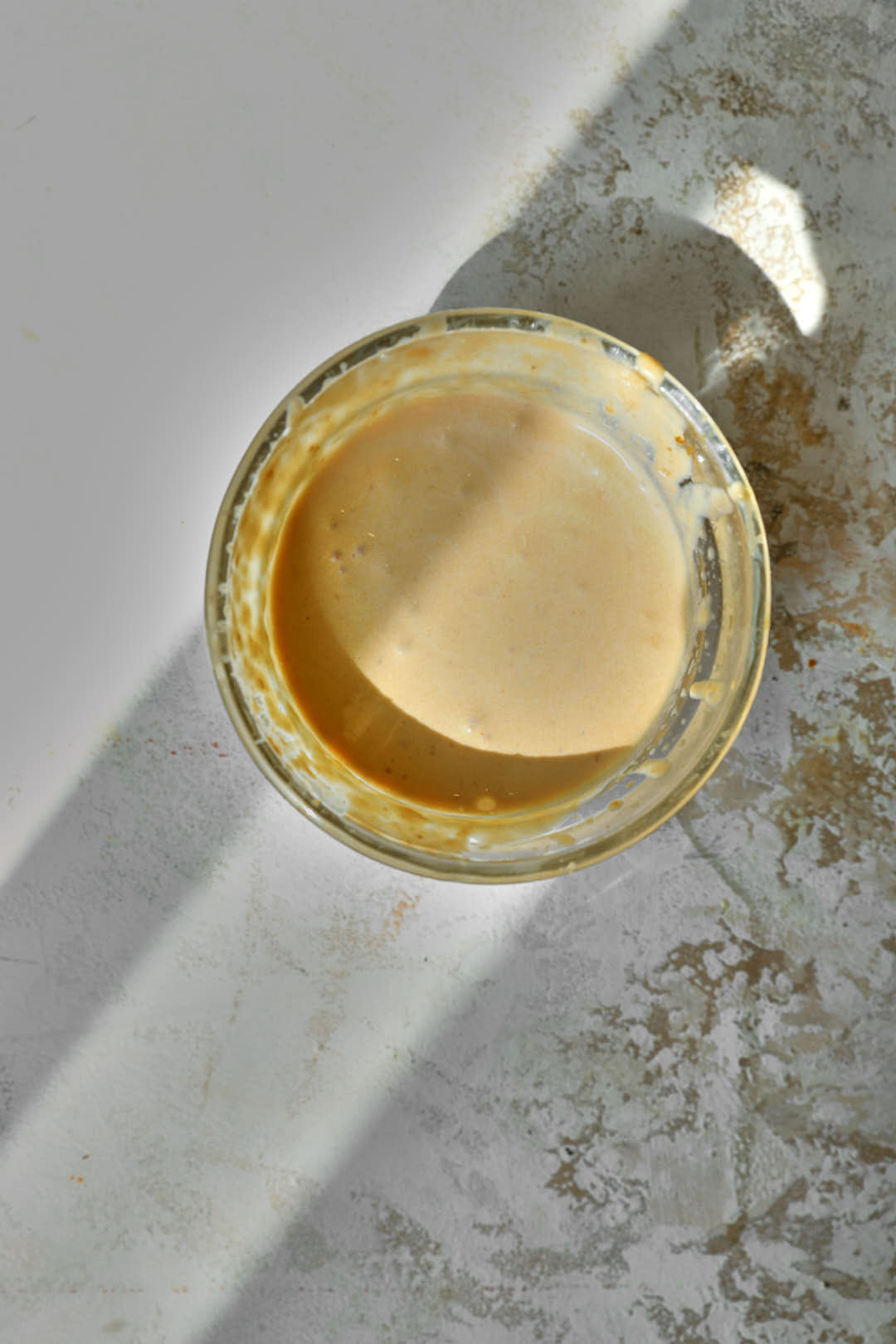pumpkin cold foam in a glass ramekin on a white background.