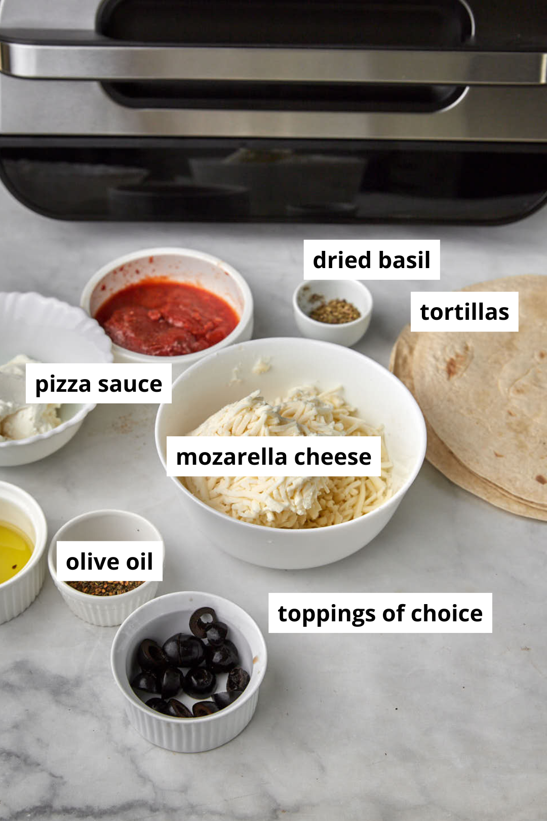 ingredients needed to make air fryer tortilla pizzas in front of a ninja air fryer