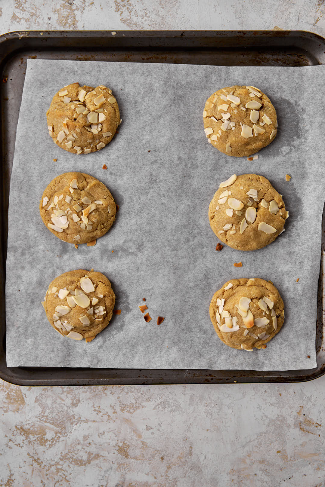baked almond cookies on parchment paper lined baking sheet