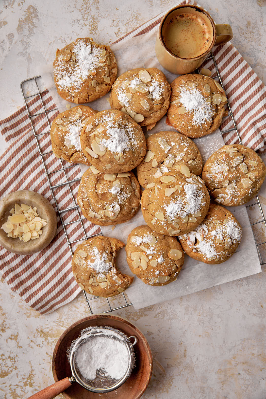 powdered sugar dusted almond cookies on wire baking rack.