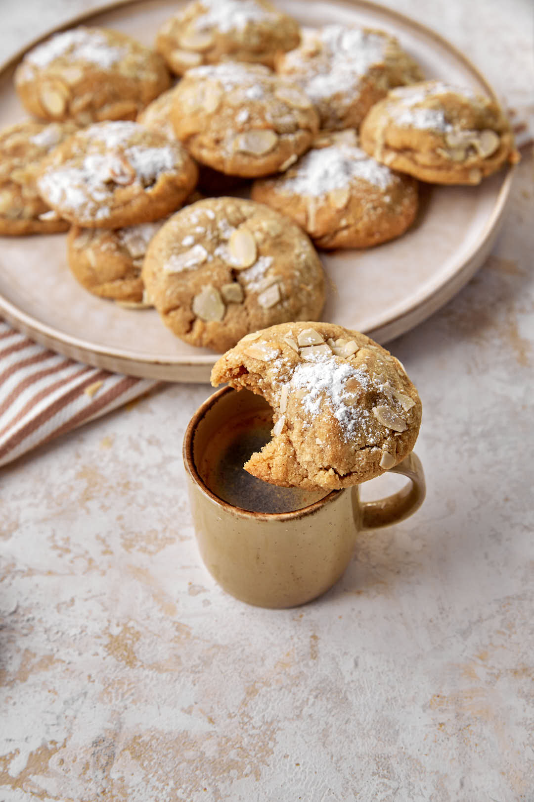 a cookie with a bite taken out of it on an espresso cup of coffee.