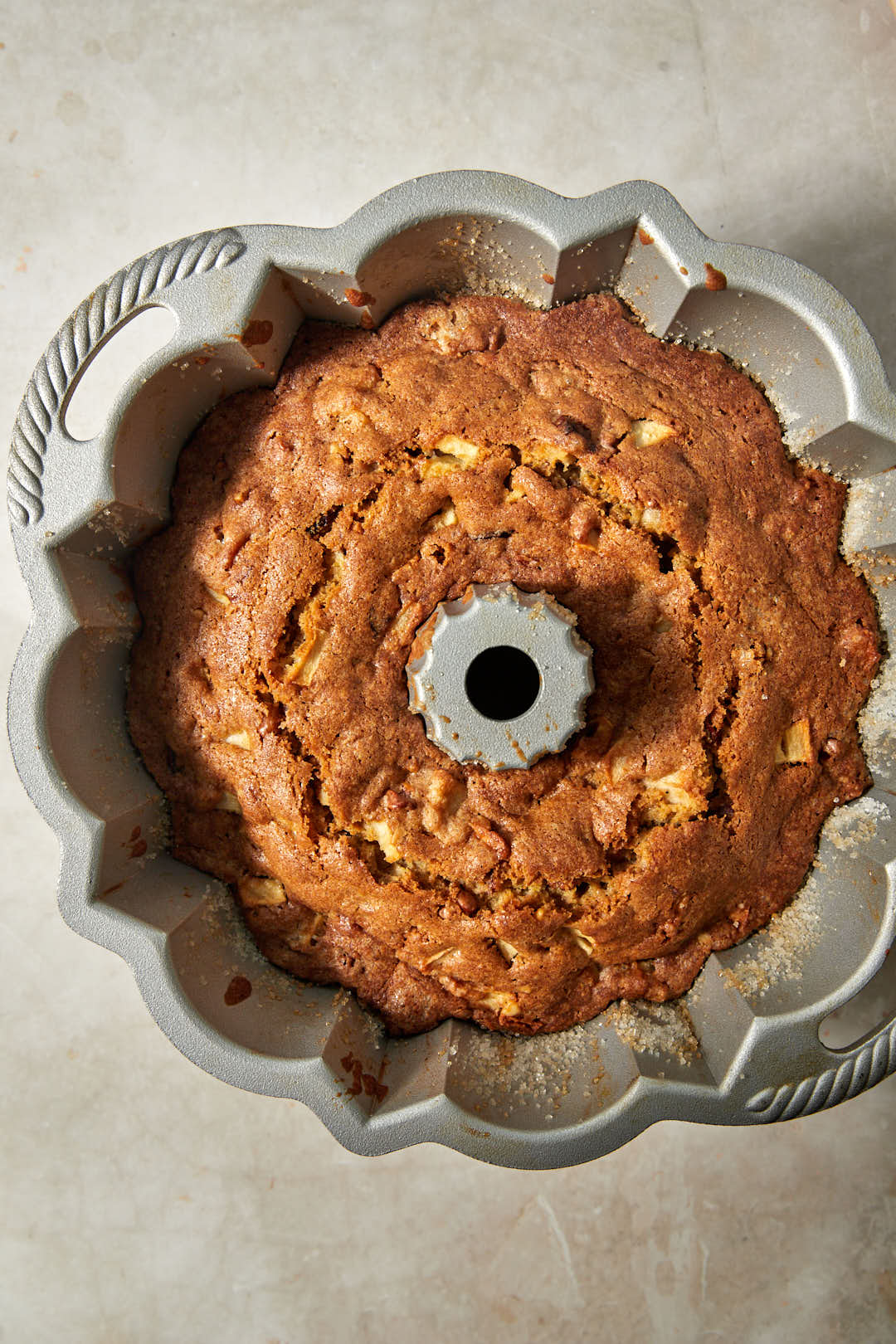 baked apple date cake in bundt cake pan cooling.
