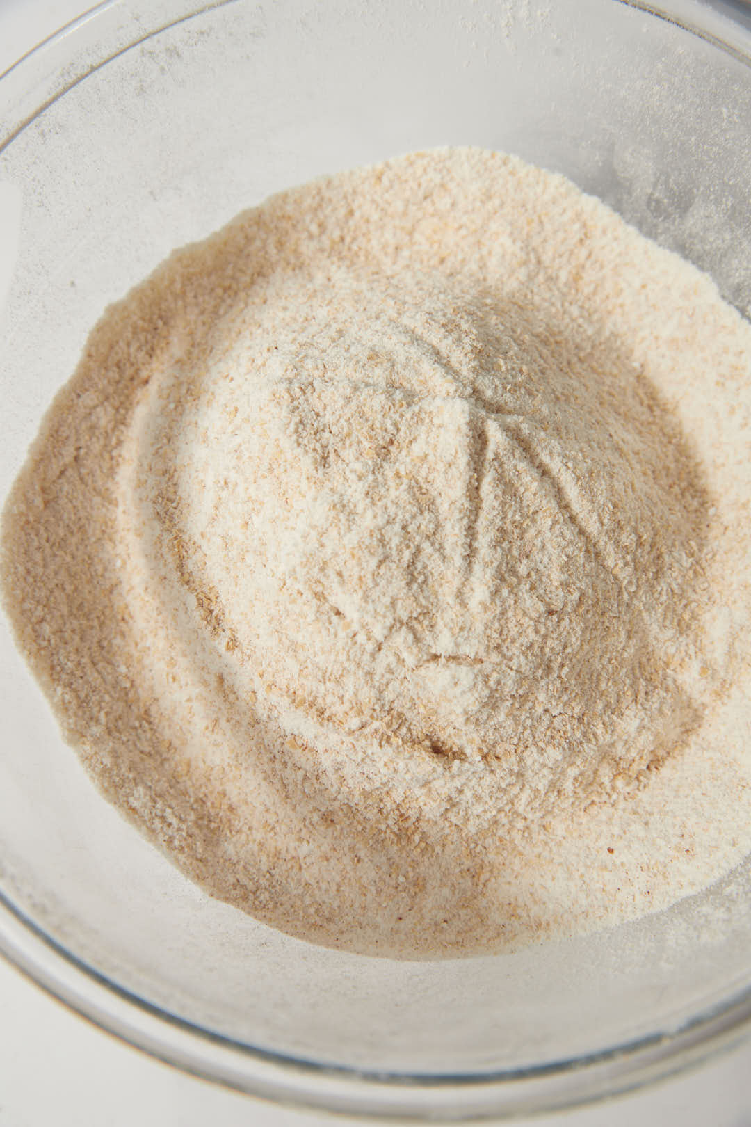 dry ingredients for a cake whisked in a glass bowl.