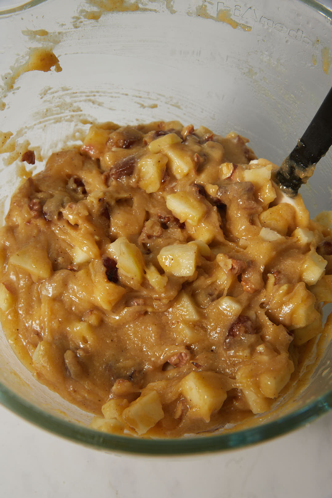 apple date walnut chunky cake batter in glass bowl.