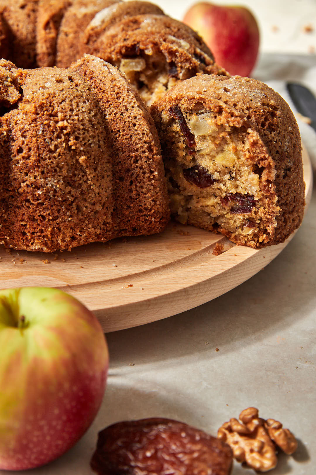 close up photo of a apple date cake being pulled out of a whole cake.