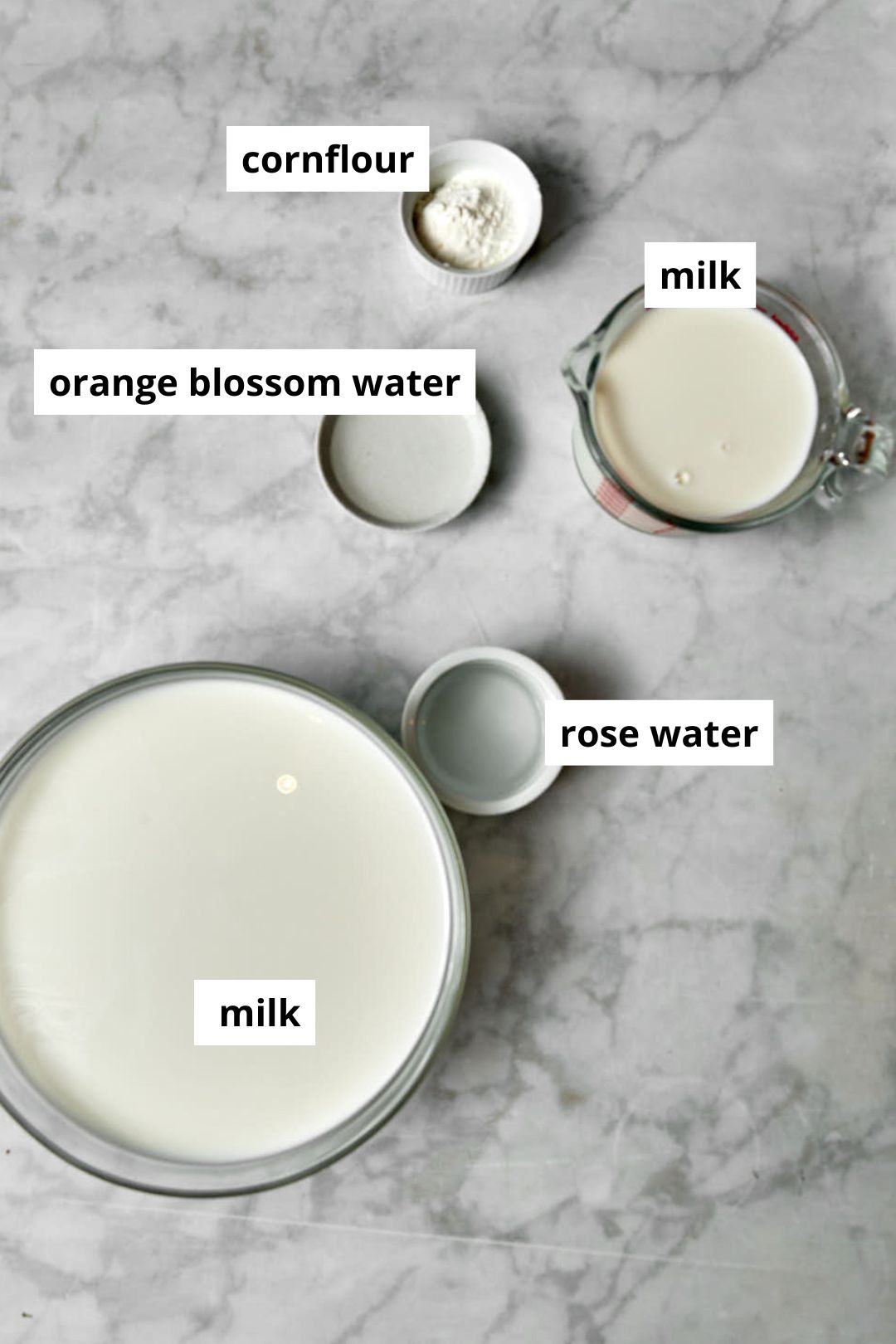 ingredients needed to make arabic ashta on a white marble background