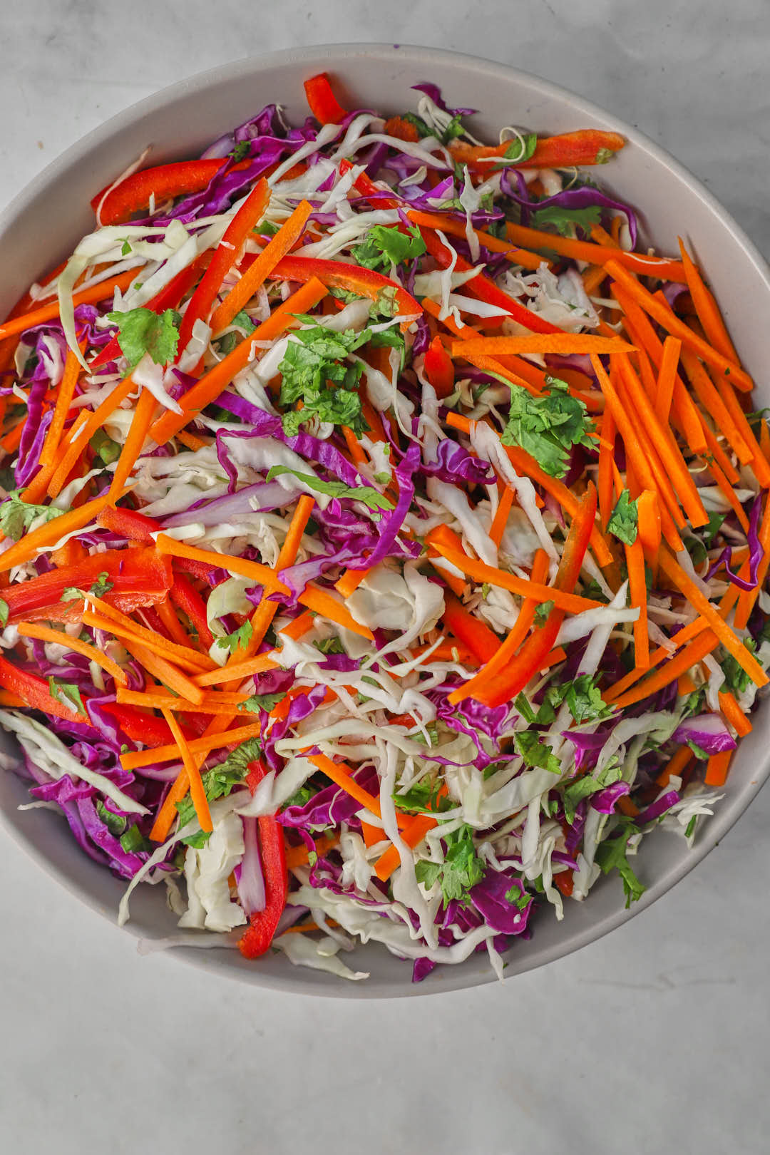 asian slaw dressings combined in a gray bowl.