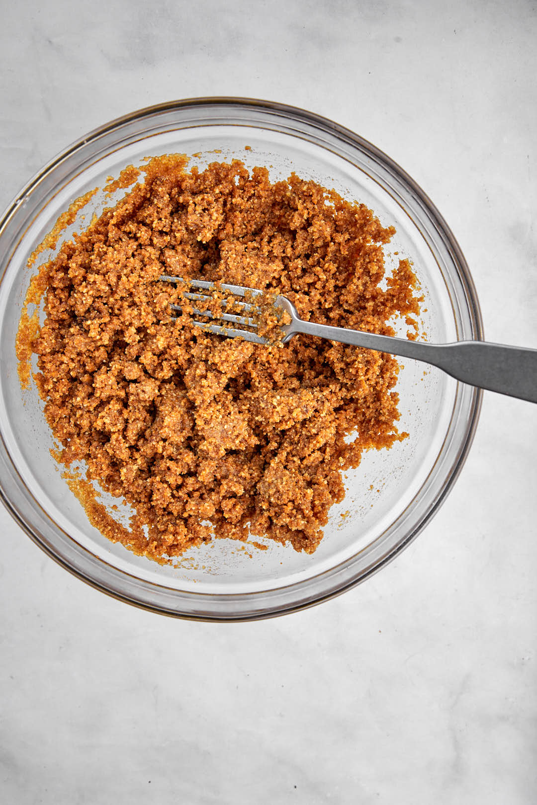 biscuit base for cheesecake in a bowl with fork.