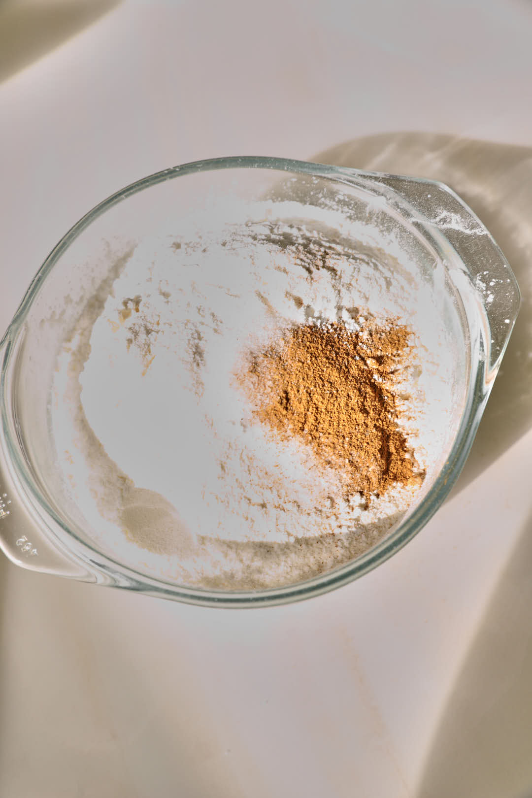 Flour, cinnamon, baking soda, and salt in a small glass bowl.