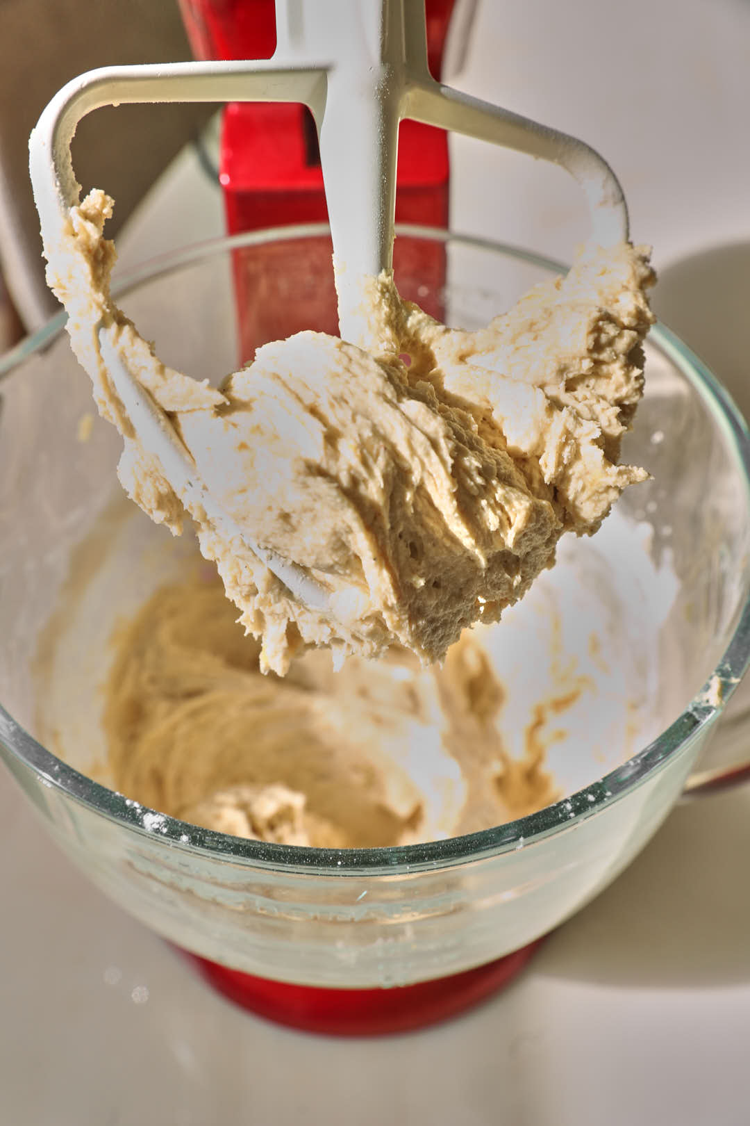 banana chocolate chip cookie dough in a glass bowl with a white paddle attachment.