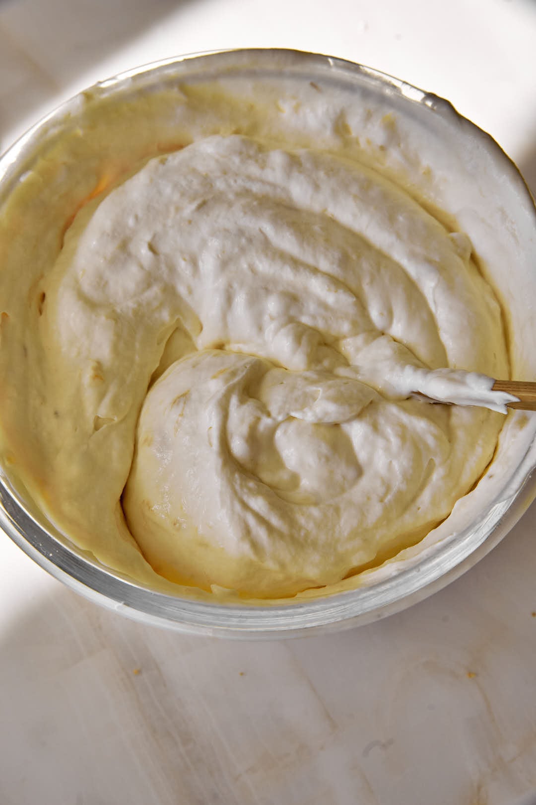 banoffee ice cream mixture in a glass bowl with a spoon.