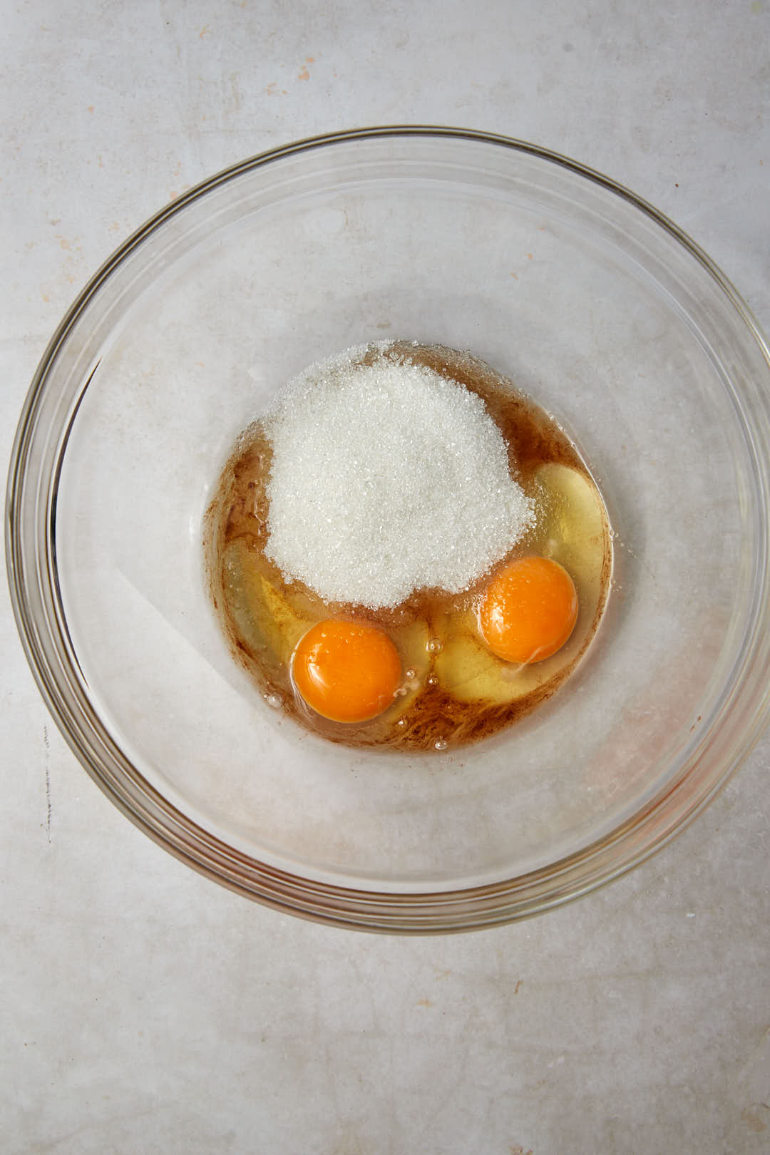 eggs, sugar and vanilla in a clear glass bowl.