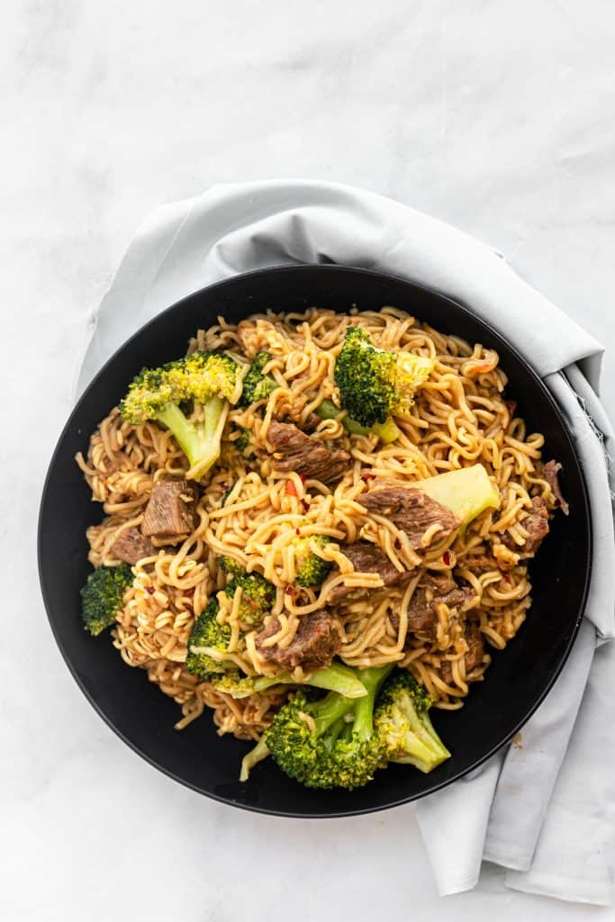 picture of completed beef and broccoli noodles dish in black bowl