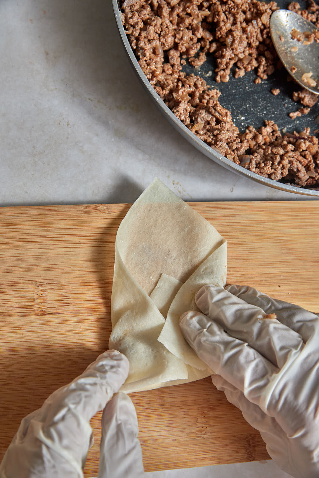 spring roll being folded over filling.