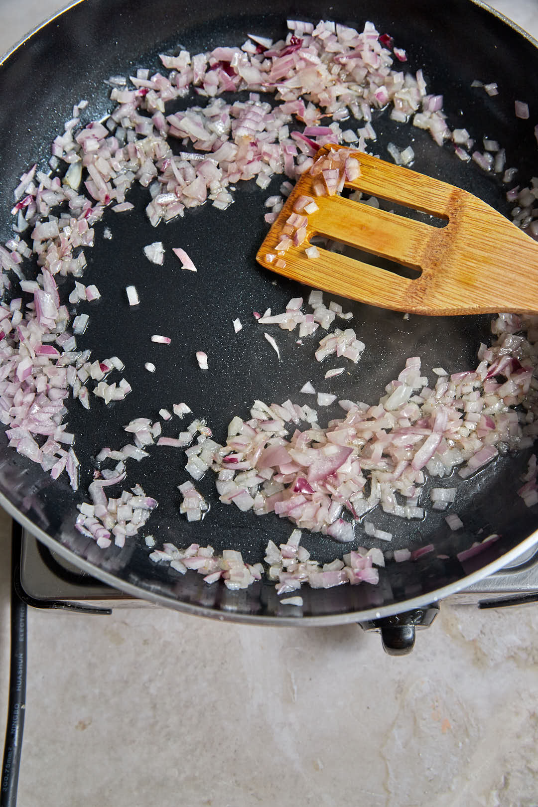 diced red onions after softening in a black skillet.