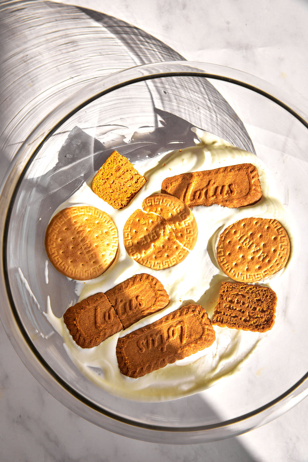 biscoff and marie biscuits on top of pudding in a glass bowl.