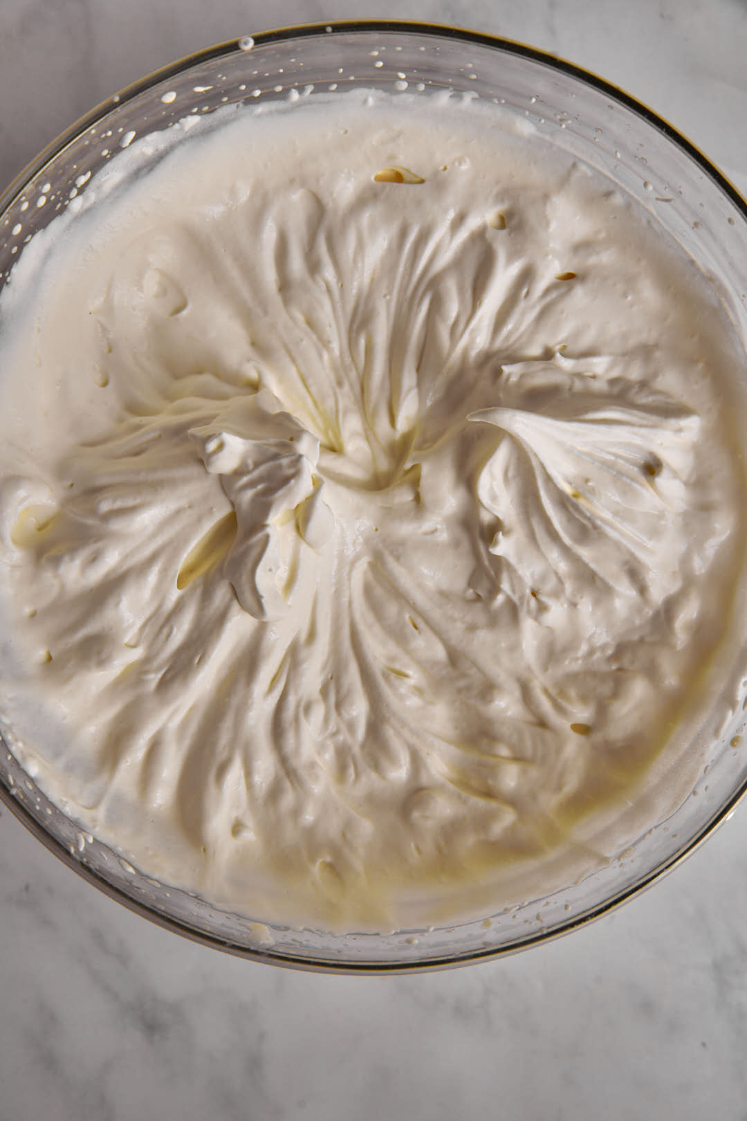 stiff peaks of heavy cream in a glass bowl.