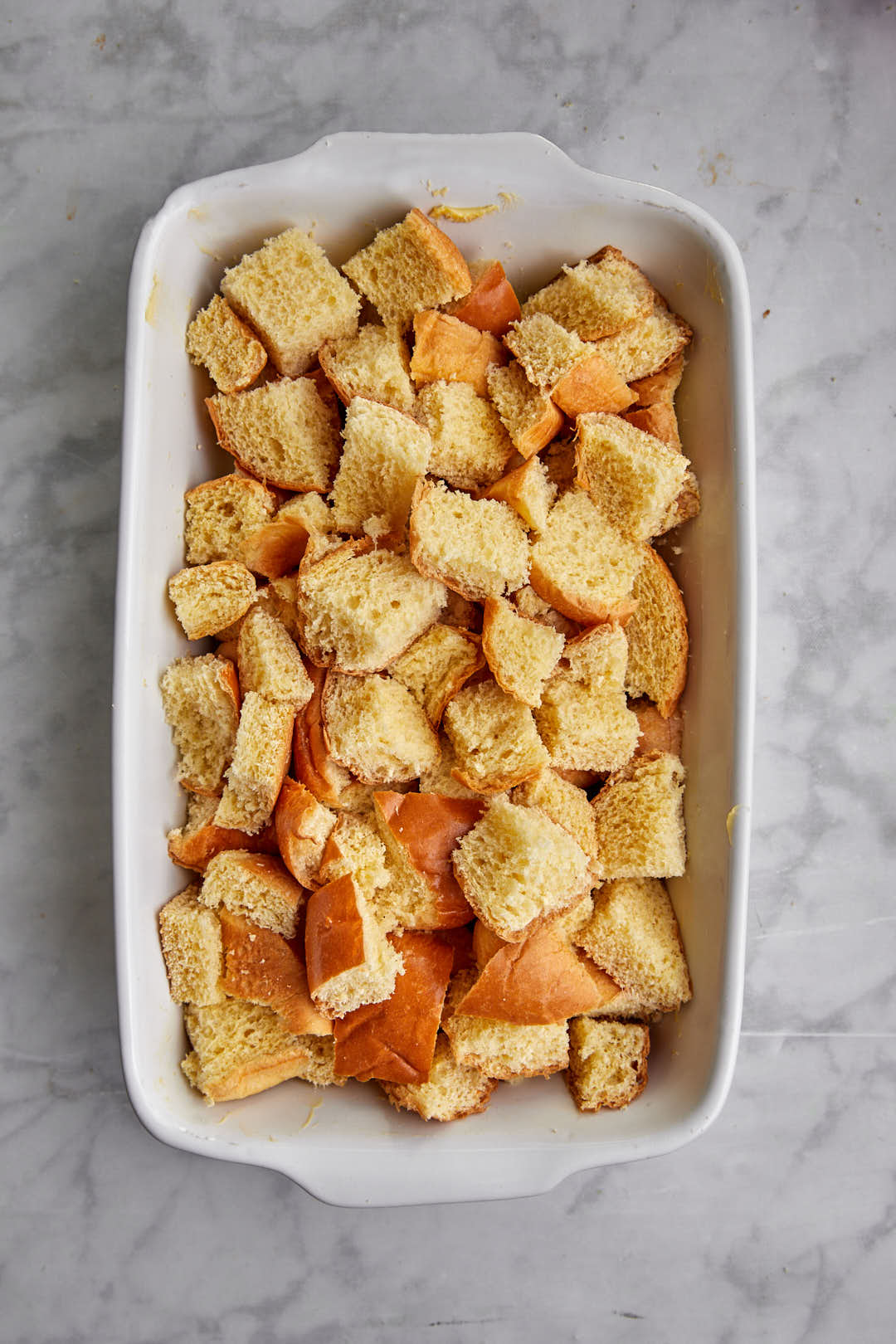 brioche cubes scattered in a baking dish.