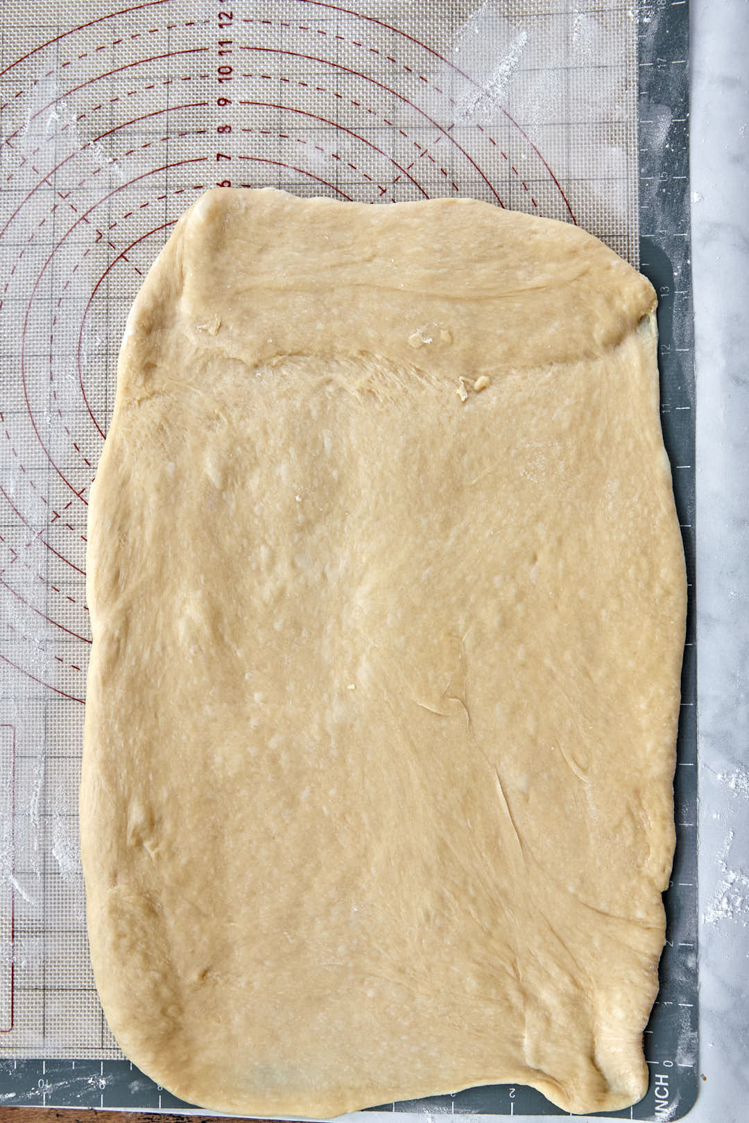 Cinnamon roll dough rolled out into a rectangle.