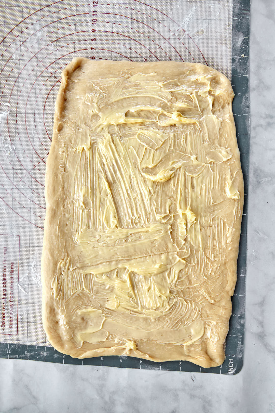 softened butter spread out onto cinnamon roll dough.