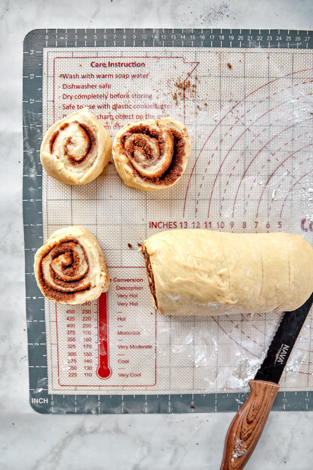 slices of cinnamon rolls being sliced off a log.