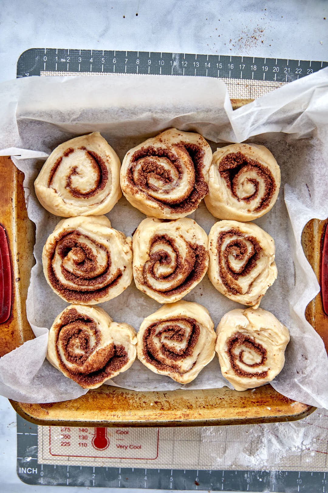 cinnamon rolls in square baking pan for their rise.