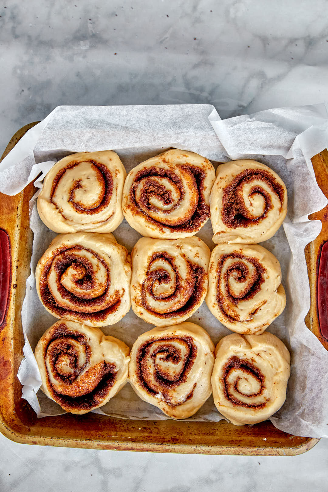 cinnamon rolls in baking pan after rising.