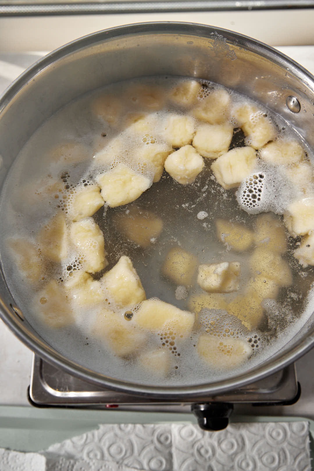 gnocchi floating to the top of boiling water in a large pot.