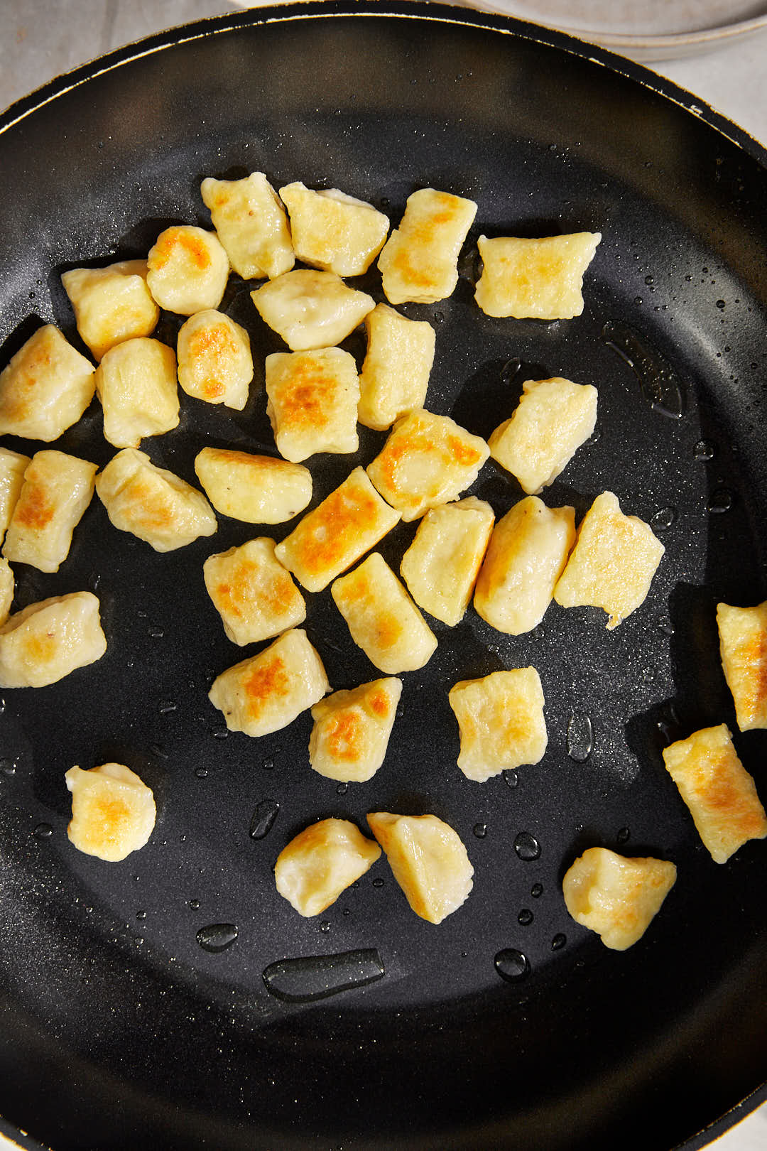crispy pan fried gnocchi in a skillet.
