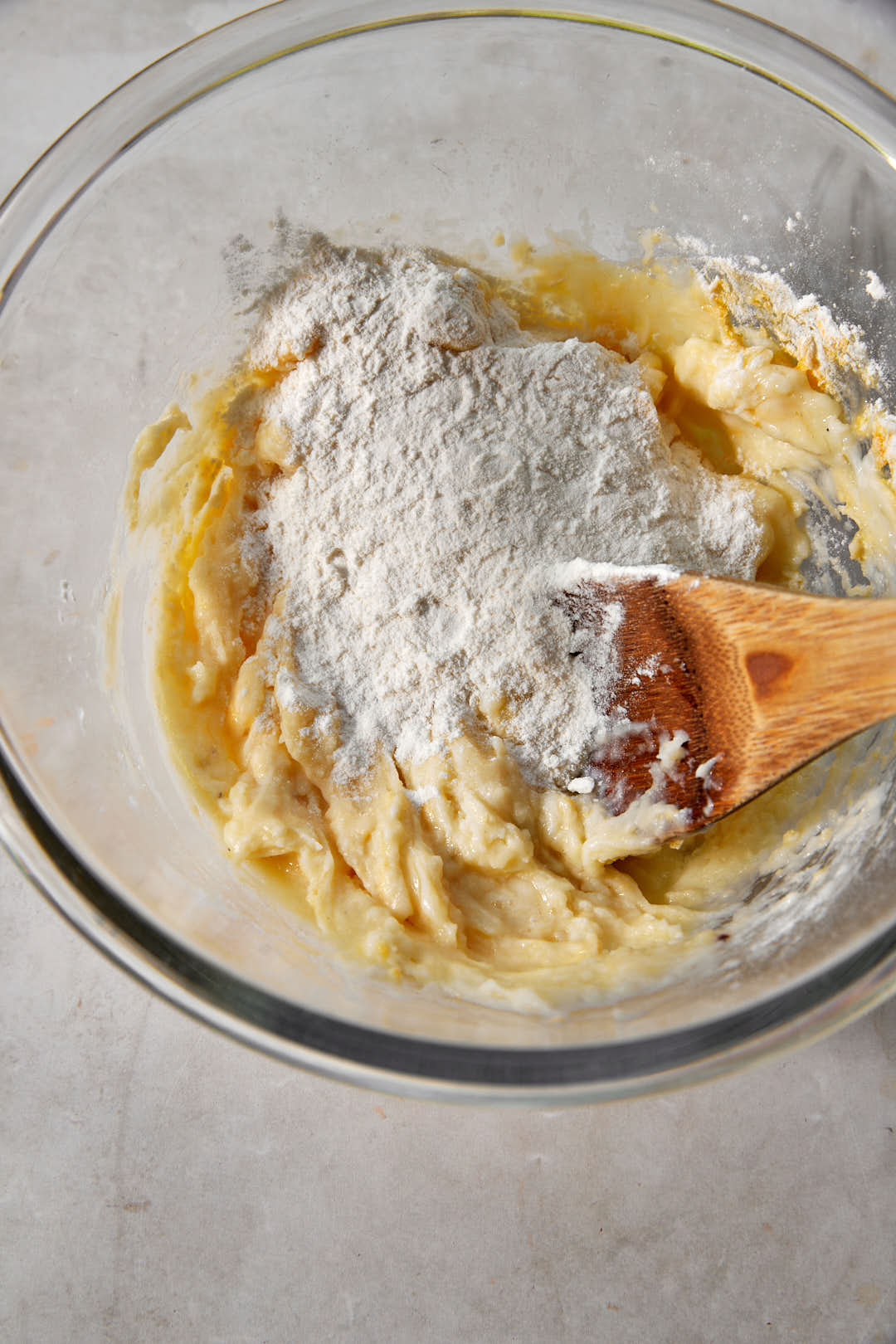 gnocchi dough in a glass bowl with extra flour added.