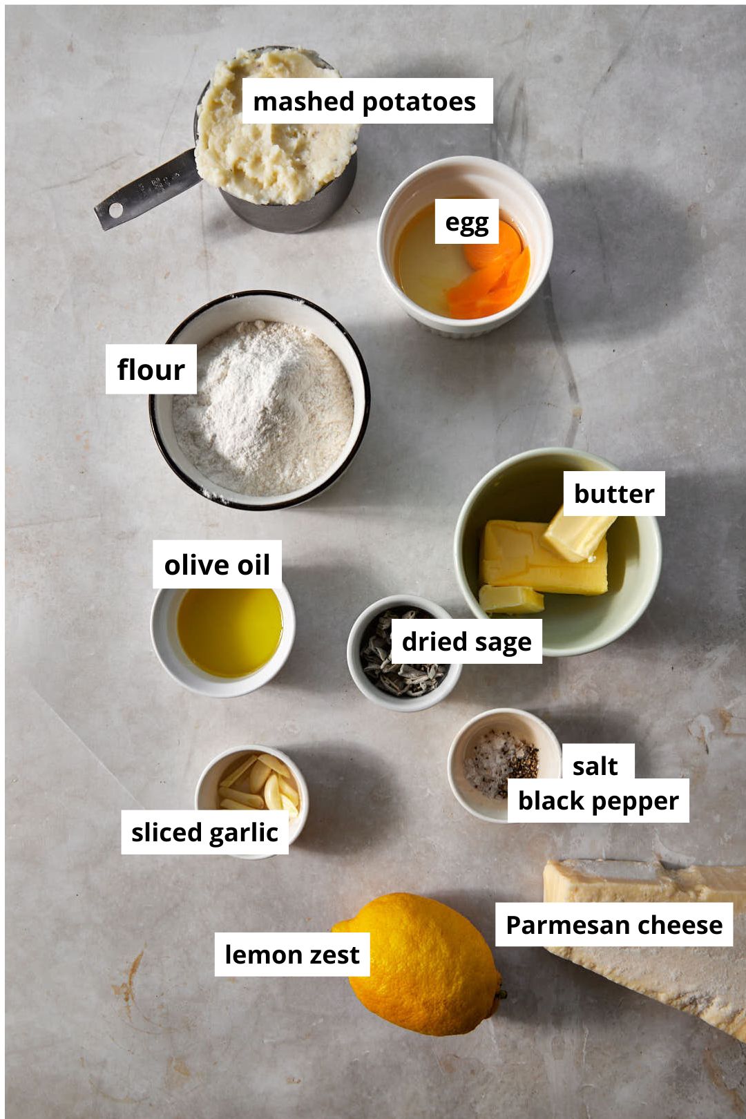 ingredients needed to make brown butter gnocchi on a beige marble backdrop