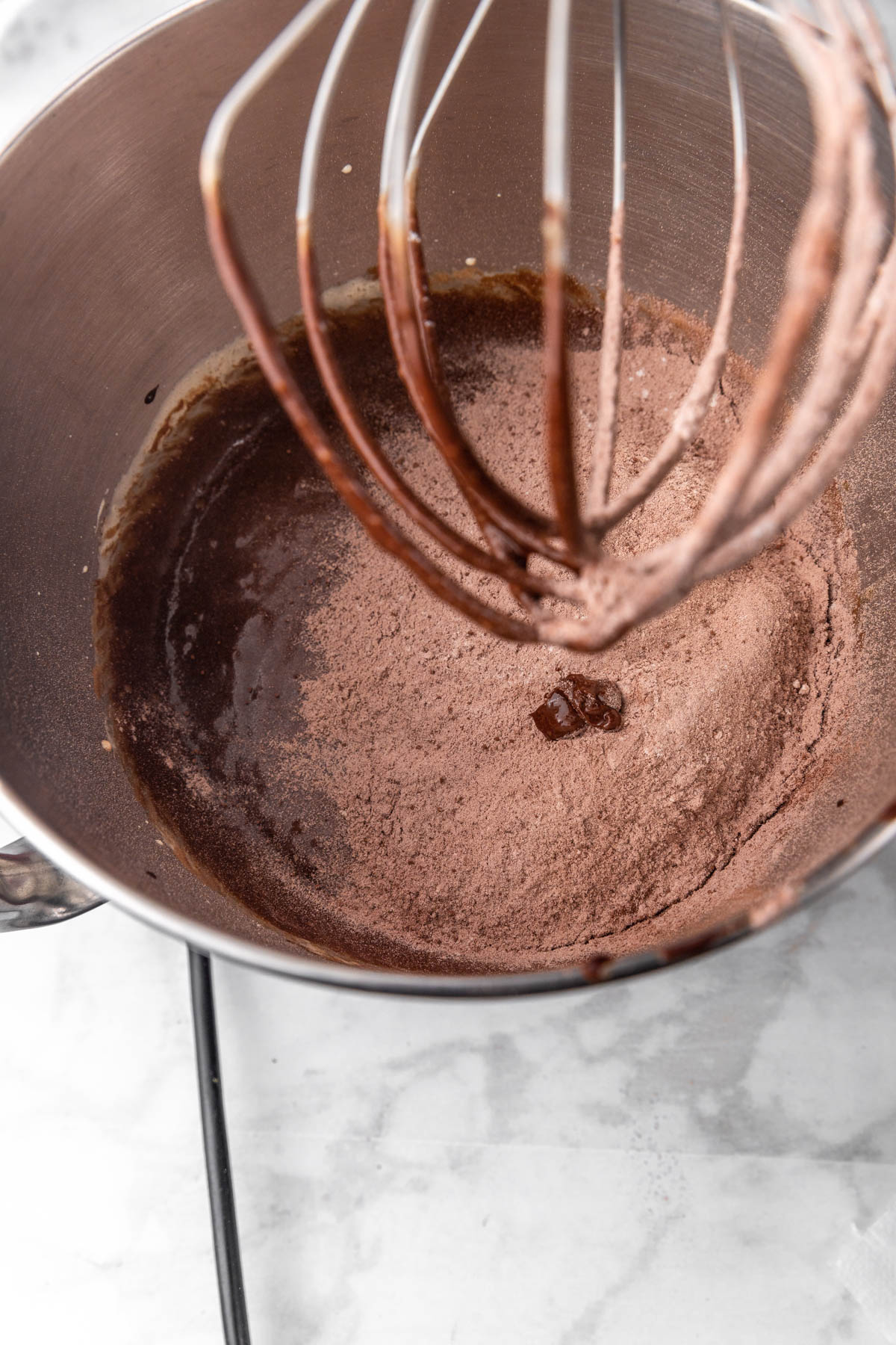 dry ingredients being added to brownie cookie batter in mixer bowl.