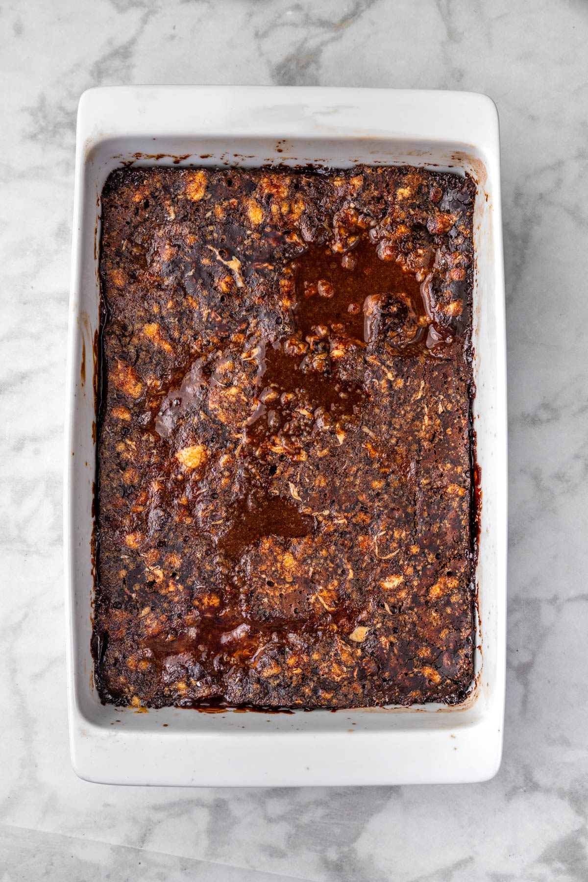 Prepared chocolate cake batter in a pan with boiling water poured over the top.