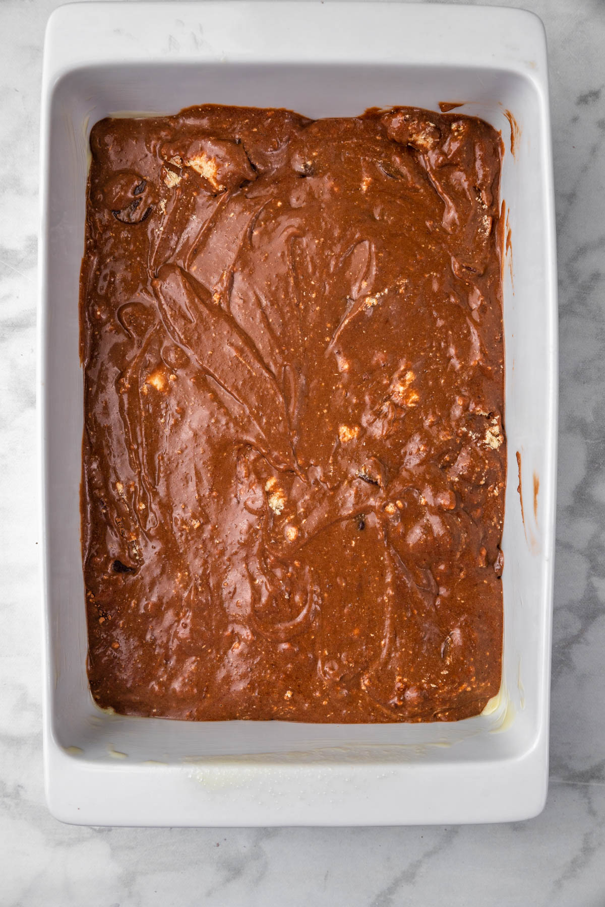 Chocolate halva cake batter in baking dish.