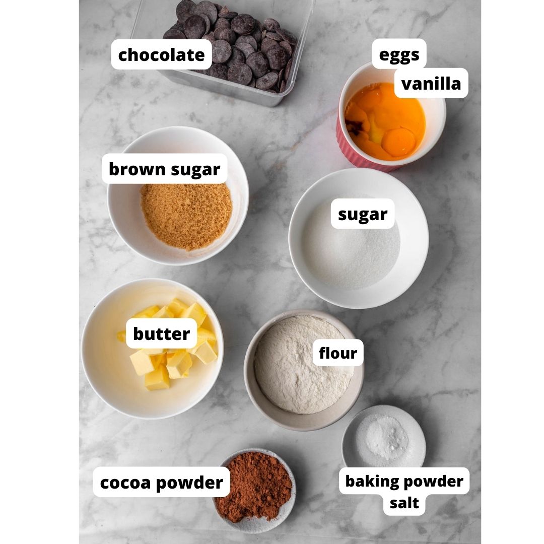 ingredients needed to make brownie cookies on white marble background.