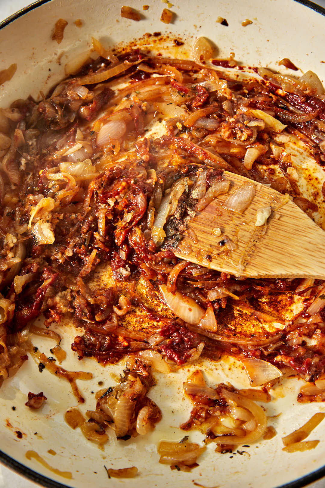caramelized onions stirred together with tomato paste and spices in a skillet.