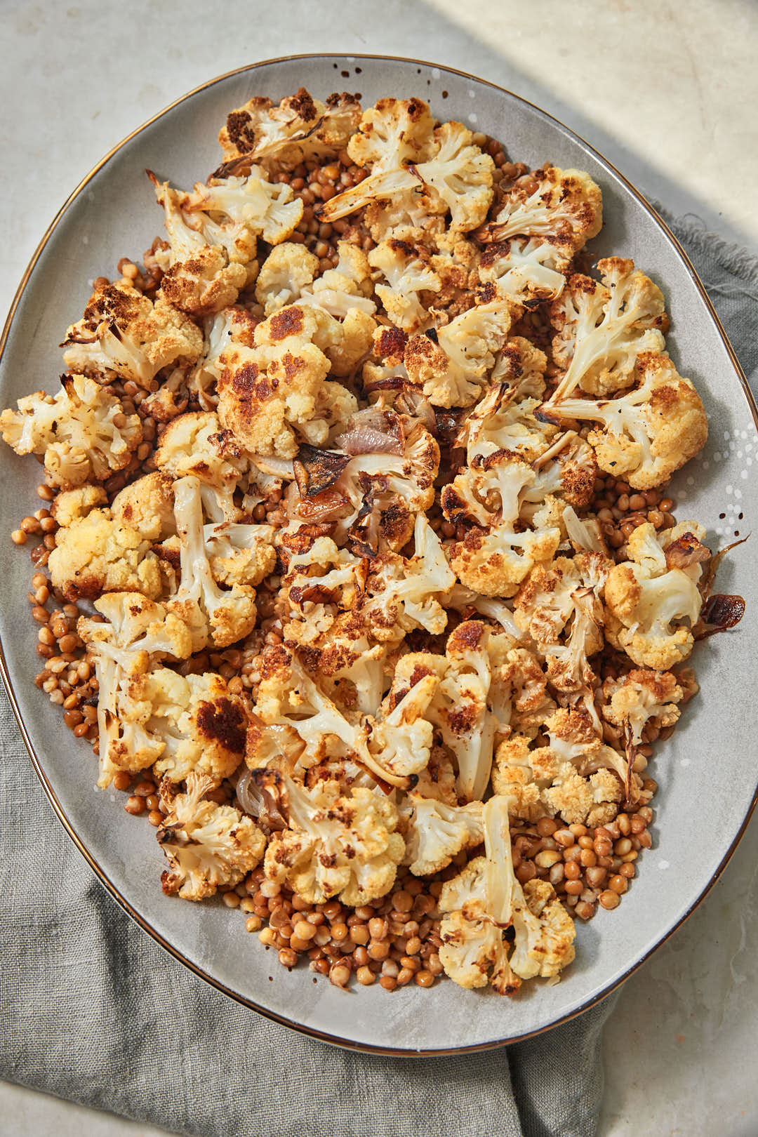 Roasted cauliflower and lentils arranged on a serving platter before adding toppings