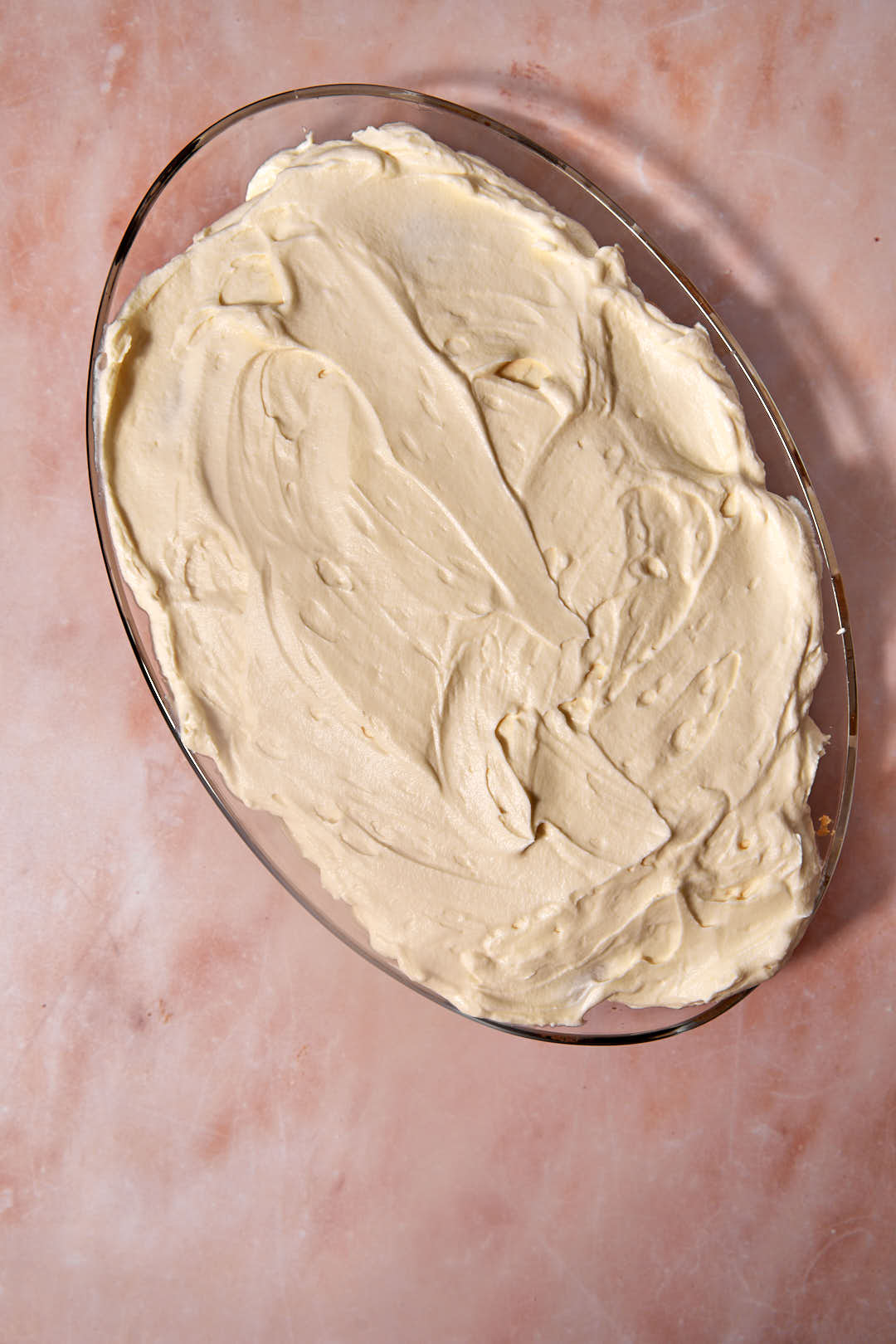 second layer of mascarpone cream mixture in pyrex dish for tiramisu.