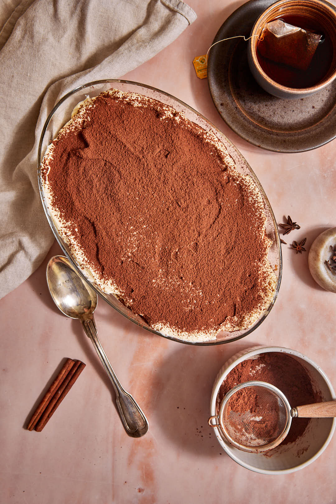 chai tiramisu on a pink background with a cup of tea.