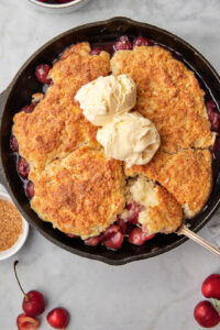 cherry cobblrer with a spoon taking a big scoop out.