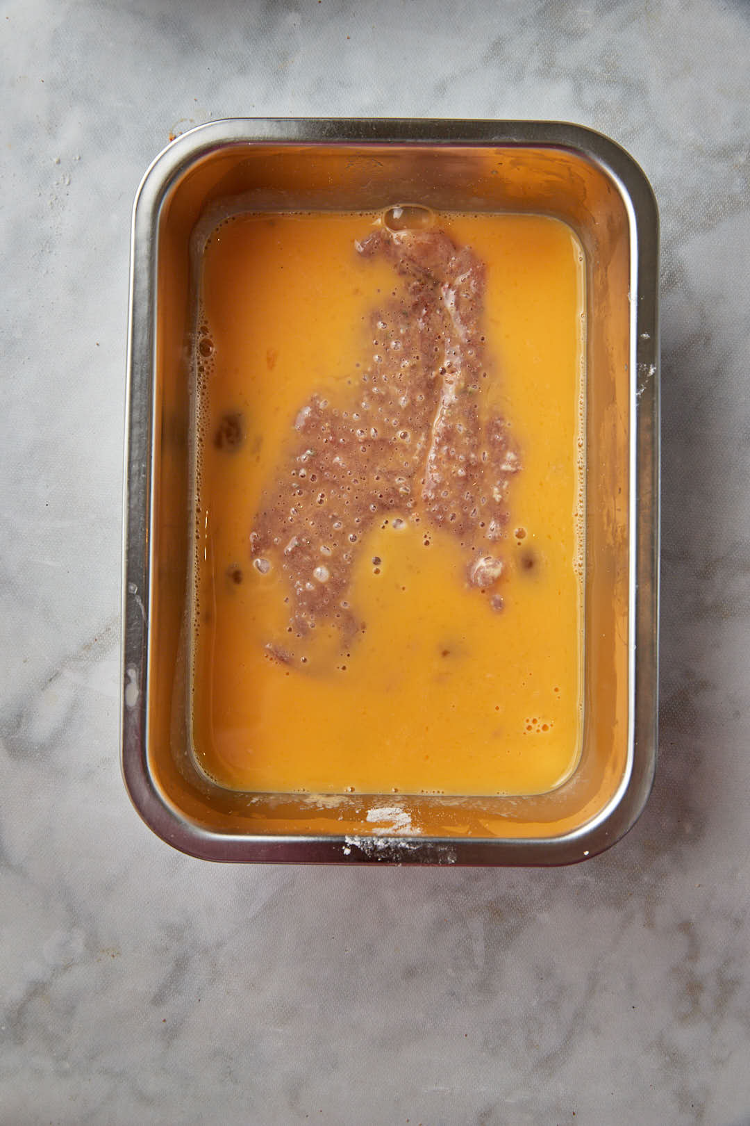 chicken breast in egg wash.