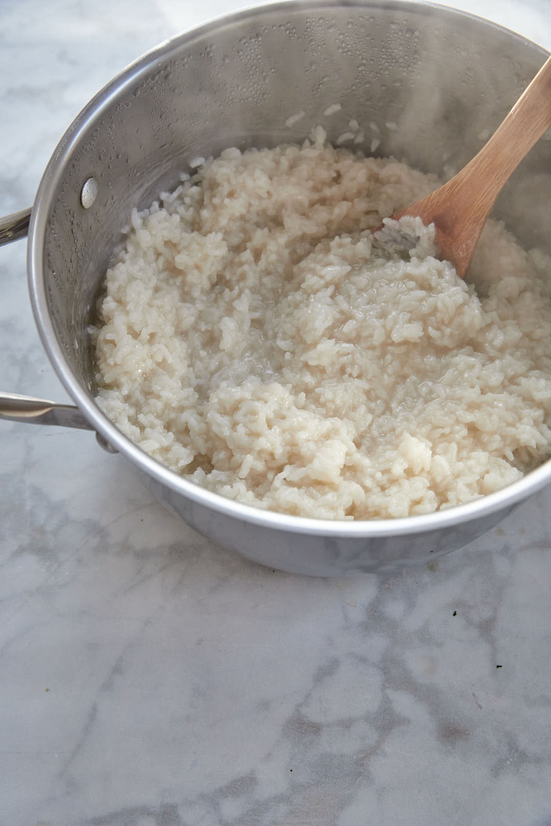 saleeg rice in the middle of cooking after it absorbs the stock in a saucepan.