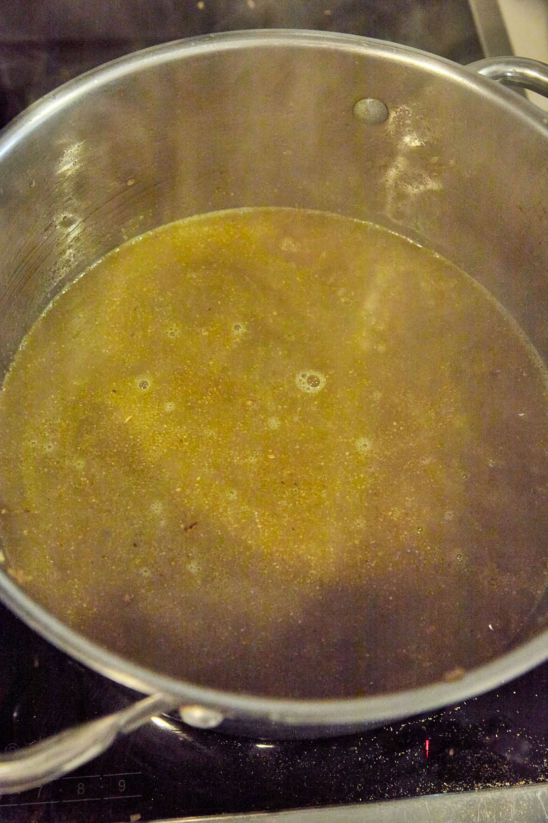 freekeh covered with broth simmering in saucepan.