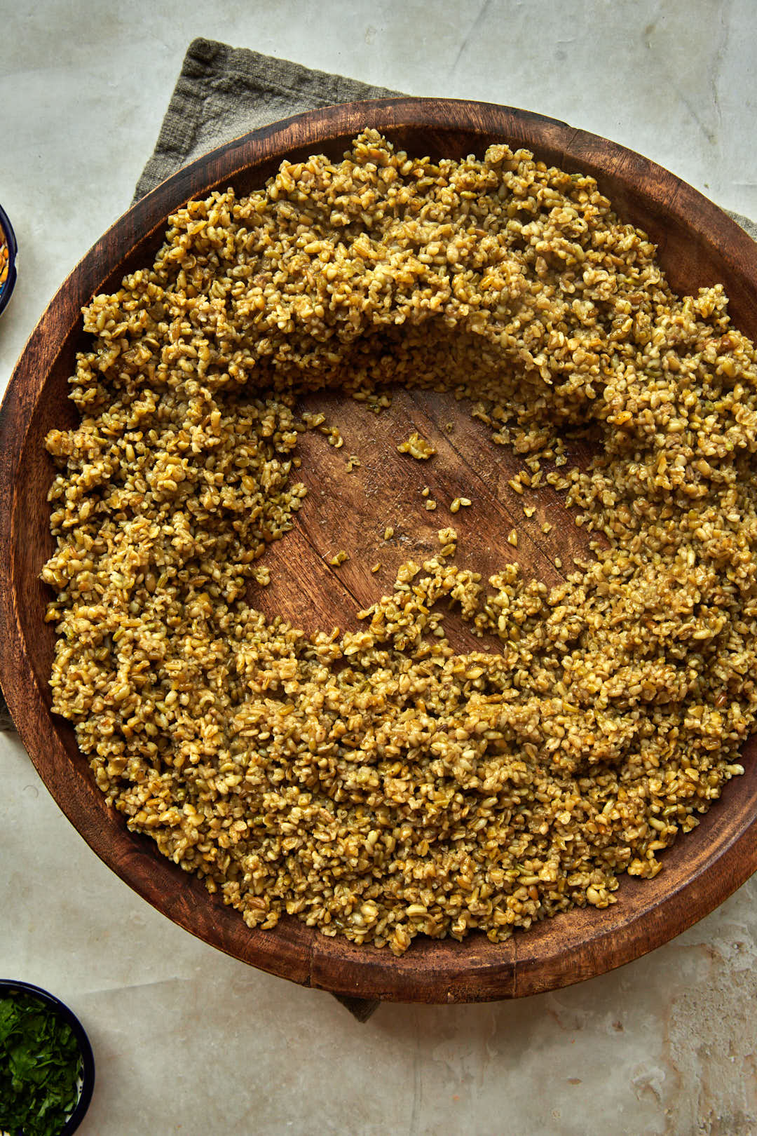 freekeh spread into a large wooden platter.